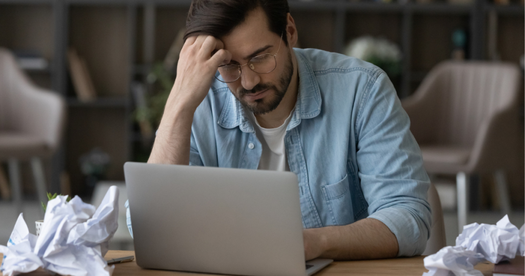 Stressad Man Med Glasögon Framför Laptop Och Skrynkligt Papper