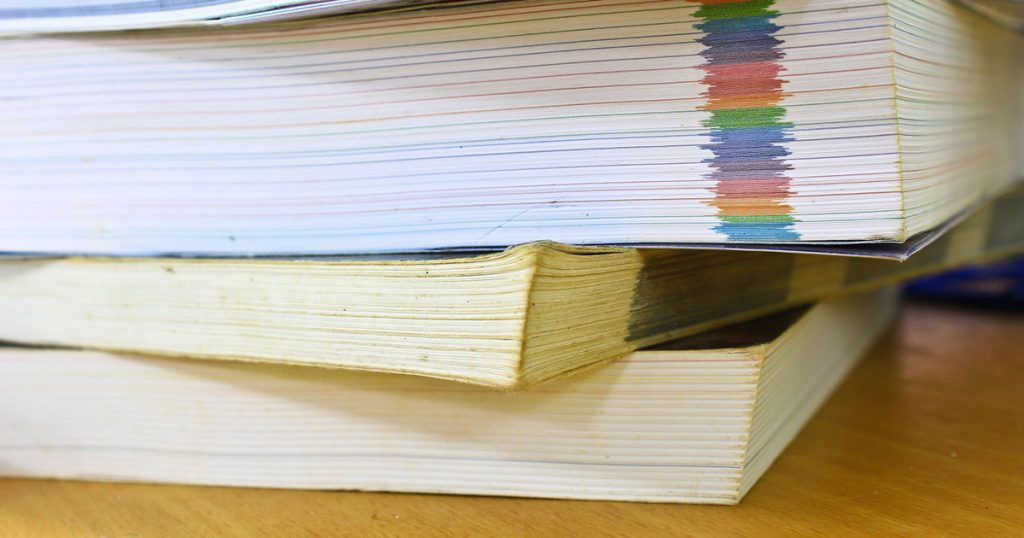 Böcker staplade på ett bord med färgade sidmarkeringar